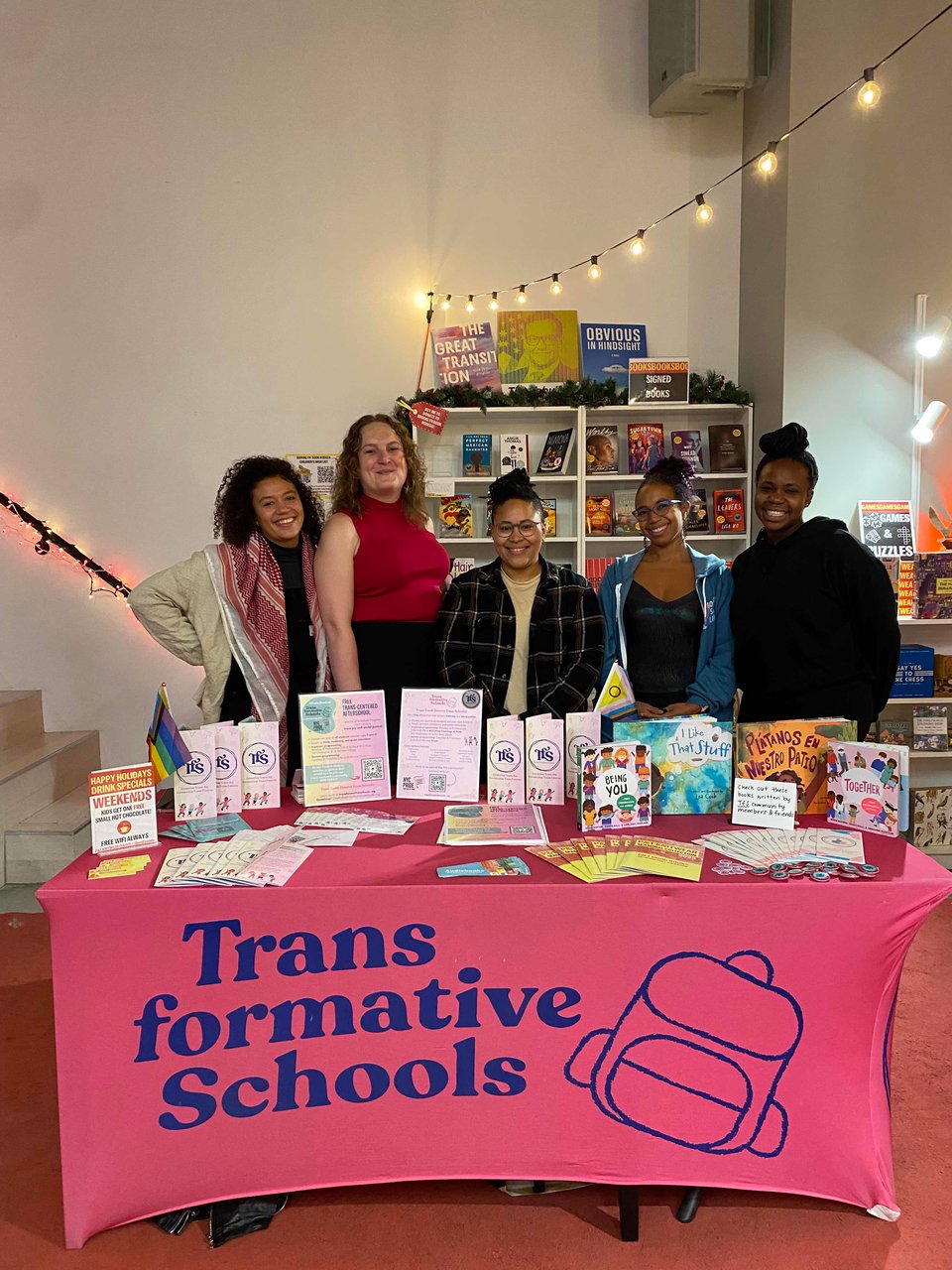 The Trans formative Schools team stands behind an information table at P&T Knitwear
