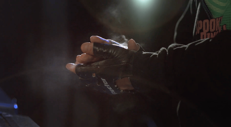 Pinball player Abe wearing a hoodie and bicycle gloves.