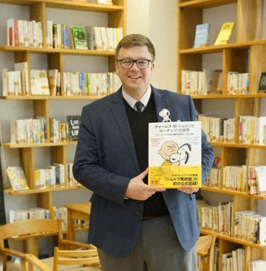 Author and museum curator Benjamin L. Clark holds a Japanese translation edition of the book Charles M. Schulz: The Life of the Peanuts Creator in 100 Objects, winner of the 2023 Eisner Award for Best Comics Related Book.