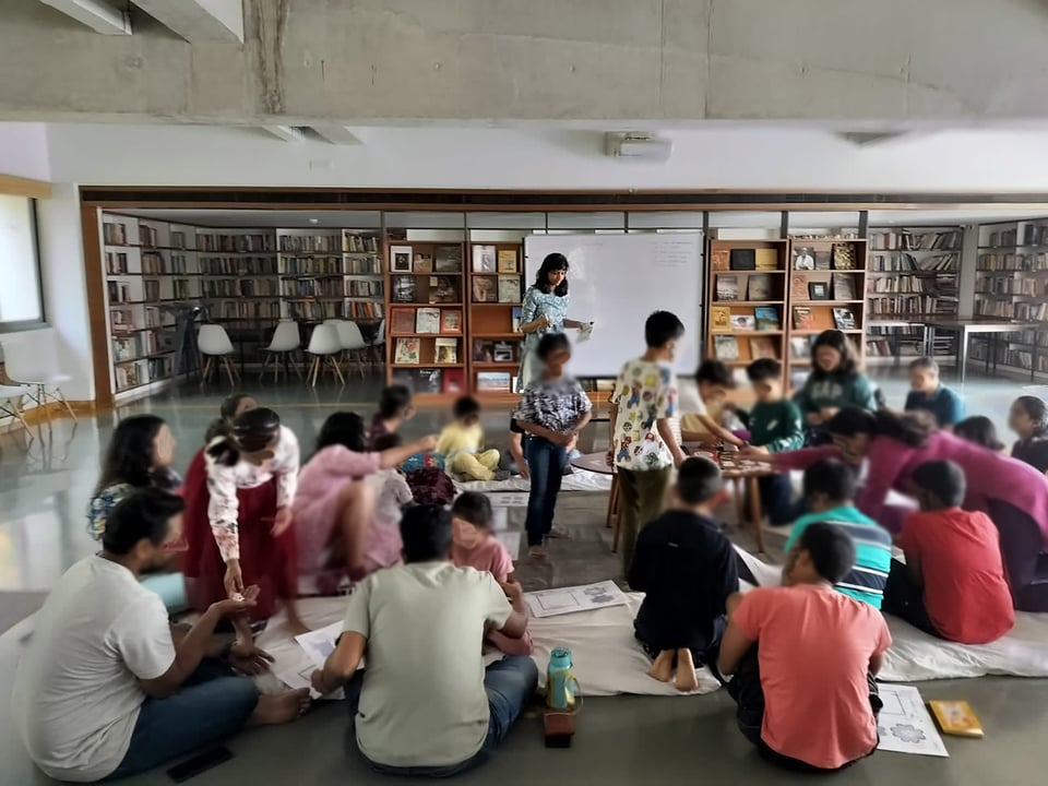 A group of children and adults in a community library.