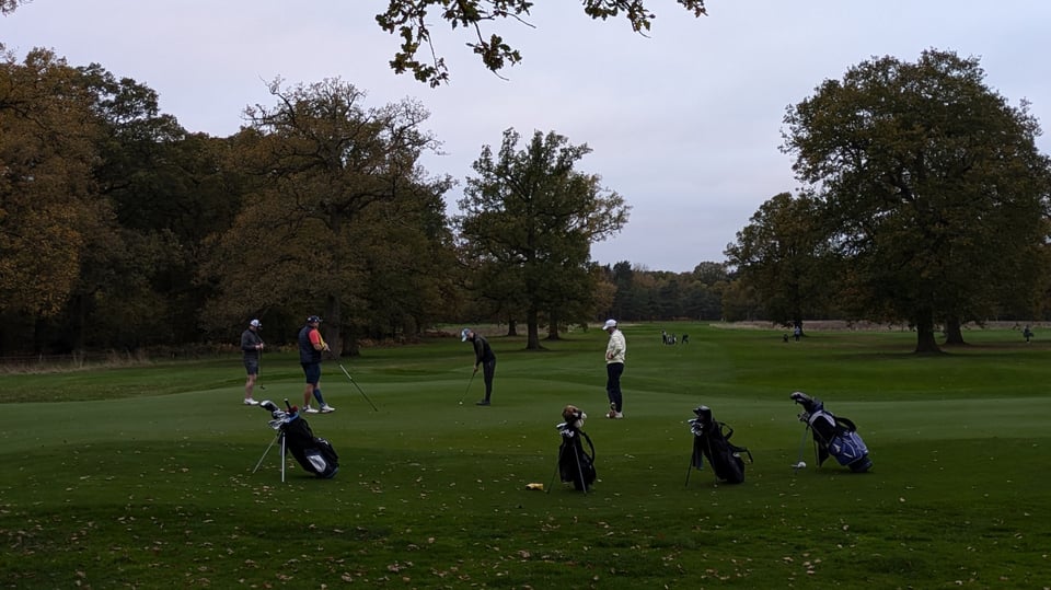 Woodhall Spa Bracken 18th green, second group of Rushcliffe mates putting out in fading light