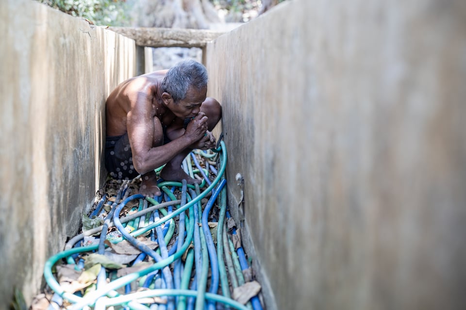 A man sucks water from a hose