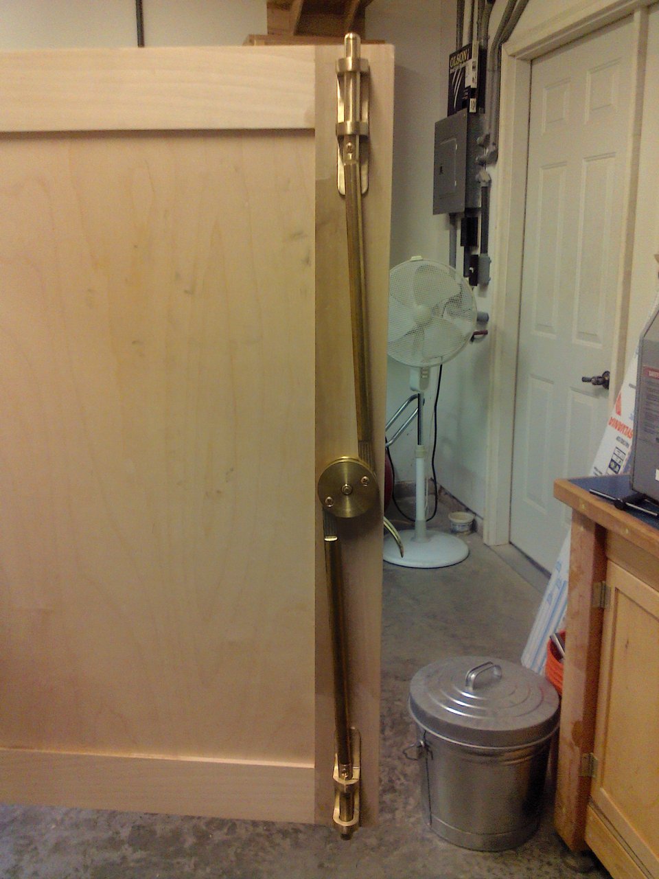 A wooden door panel with a brass latch