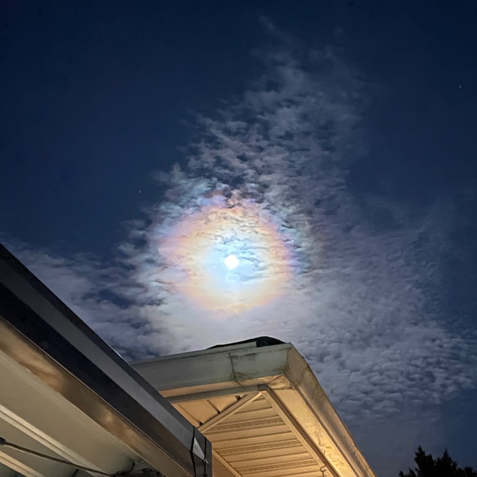 The moon behind some thin clouds, making a corona