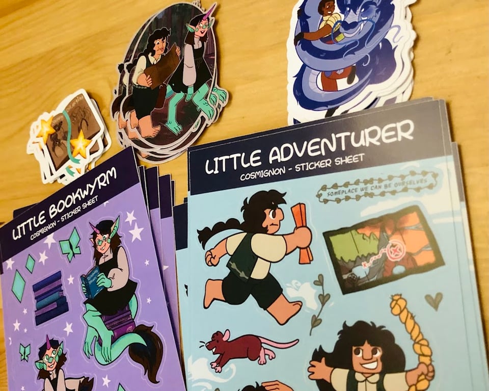 A photo of 3 sets of stickers and 2 sets of sticker sheets, all related to characters from Runaway Drakaina.