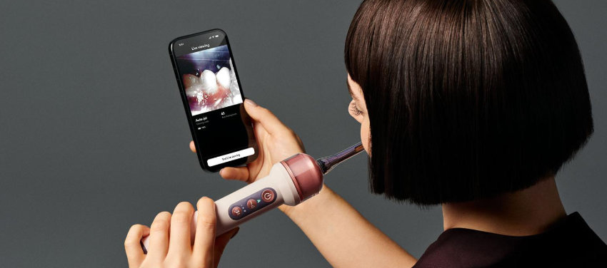 Une personne se brosse les dents tout en regardant son lavage de dents dans son application