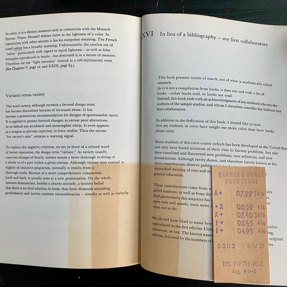 A book spread open showing two pages and an old receipt. The receipt has a series of light marks yellowish marks in the form of a blocky gradient.