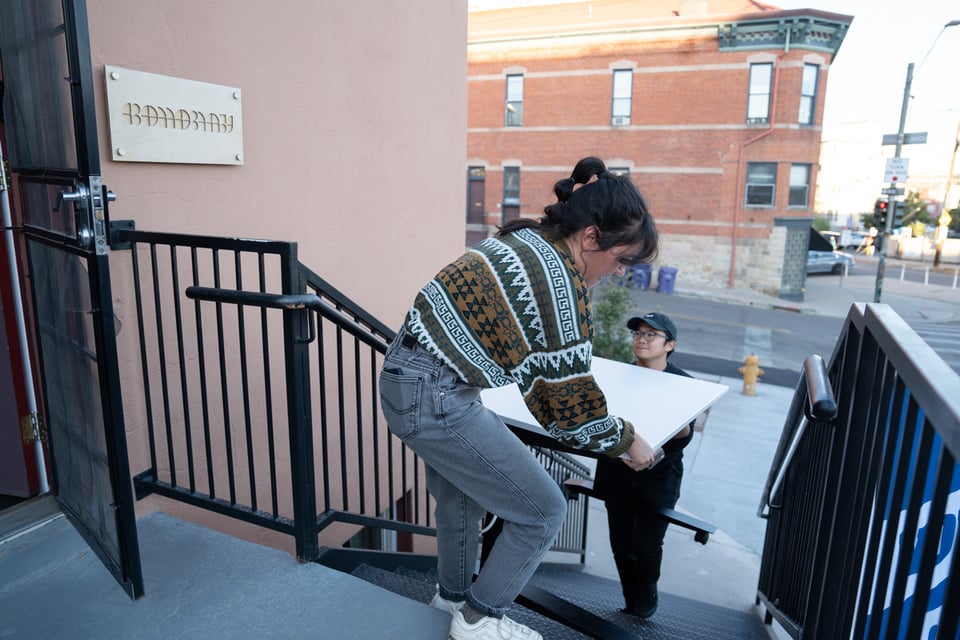 Livvy and Norton bringing her desk in.