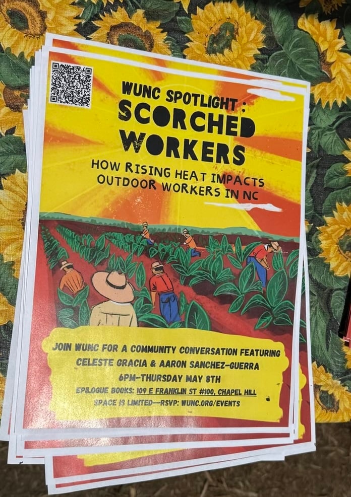 A view looking down at a stack of flyers on a folding table covered in a sunflower pattern table cloth. The flyers are for the WUNC Spotlight Scorched Workers event. The event is on May 8th at 6p at 109 E. Franklin St. #100, and an RSVP is expected at wunc.org/events.