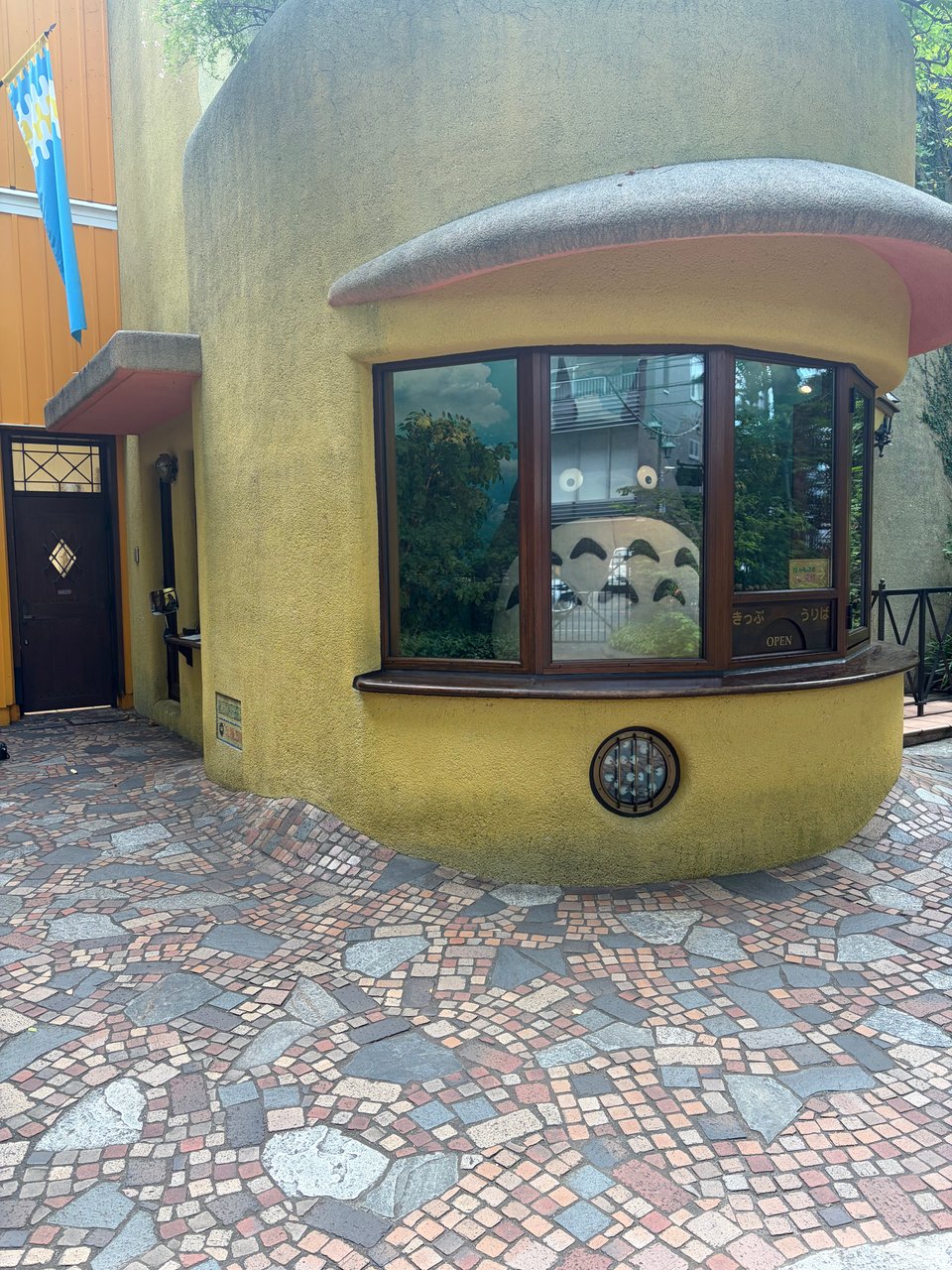 Totoro the forest spirit, massive, stands behind the ticket kiosk at the Ghibli Museum