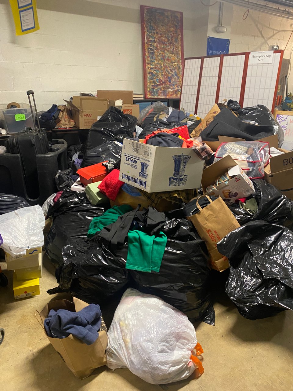 Several hundred pounds of donated clothing in boxes and bags 