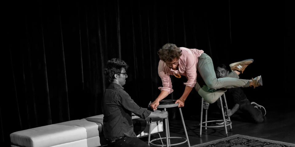 Gael jumps athletically about a chair.