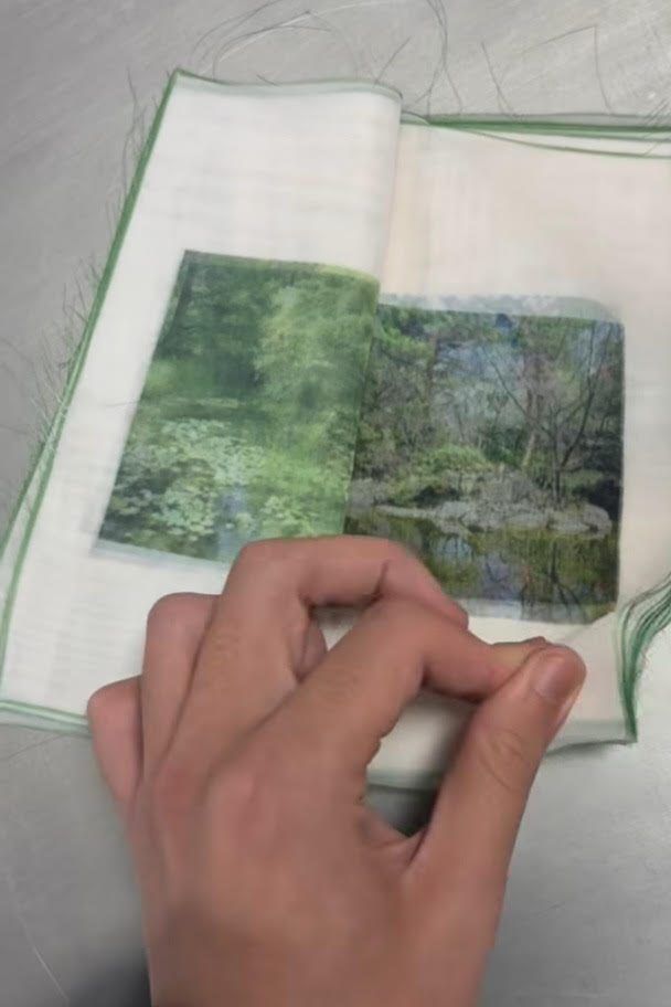 Un livre en tissu très fluide dont les pages représentent un paysage de nature un peu dans le style de Monet