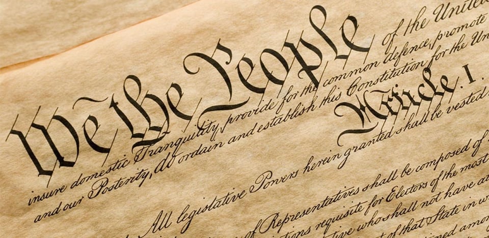An image of a handwritten copy of the start of the United States constitution.