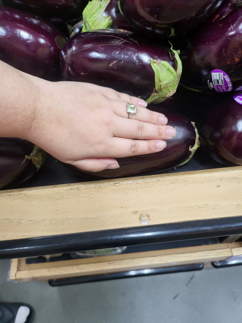 Becca's hand next to this very large eggplant.
