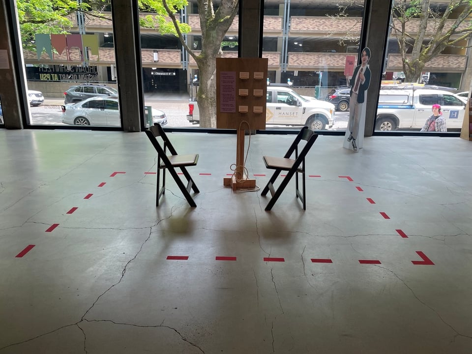 two chairs face each other in a red marked box with a sign behind them