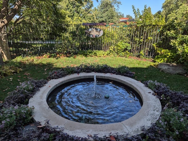 A circular water fountain in the middle of garden
