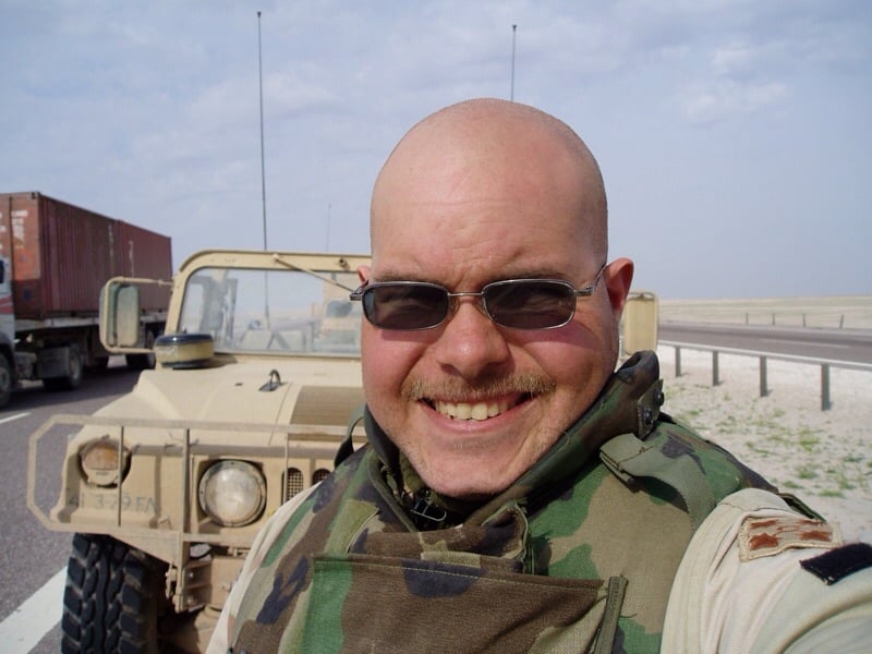 a soldier taking a selfie in front of a jeep