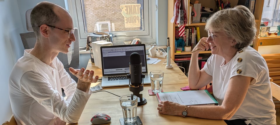 Matt and Karen chatting animatedly with a microphone and laptop between them