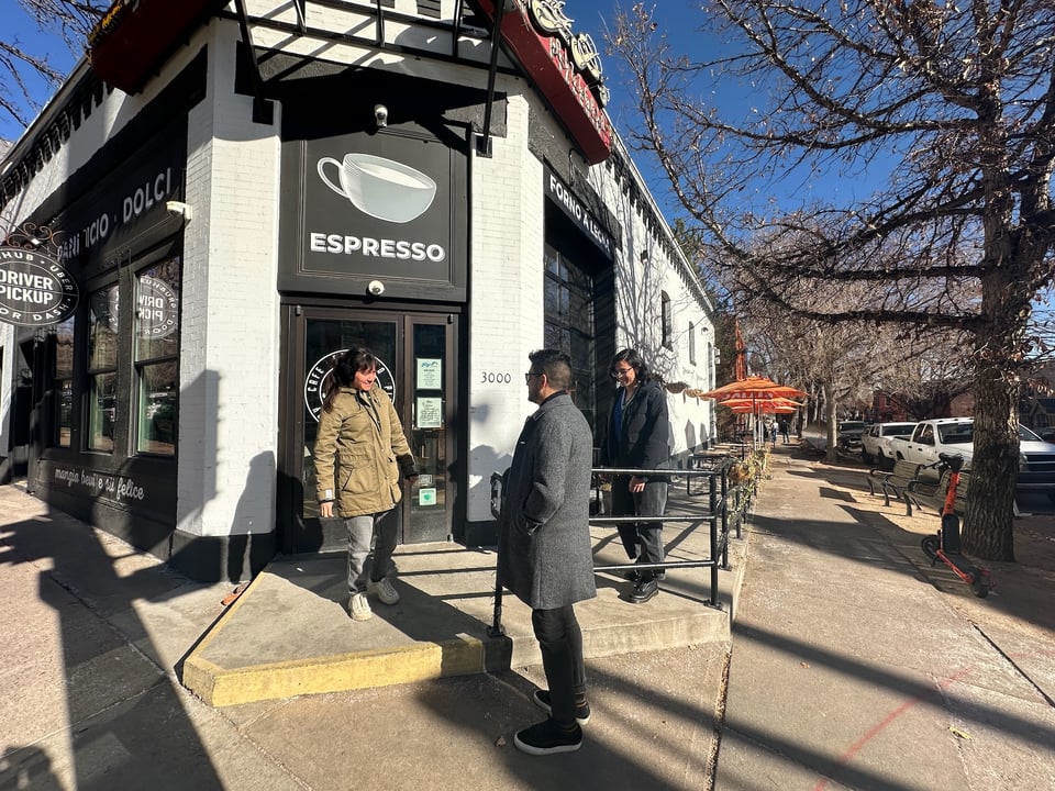 A few people standing sadly in front of a closed restaurant.