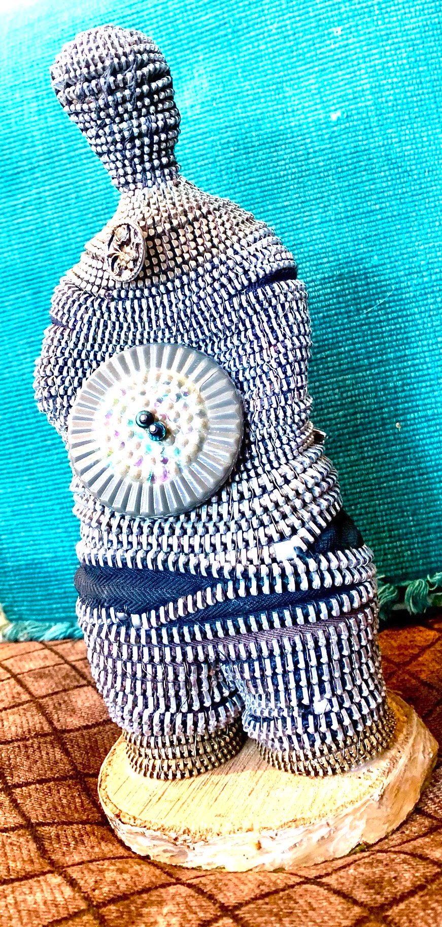Sculpture of a man made with coiled zippers and buttons