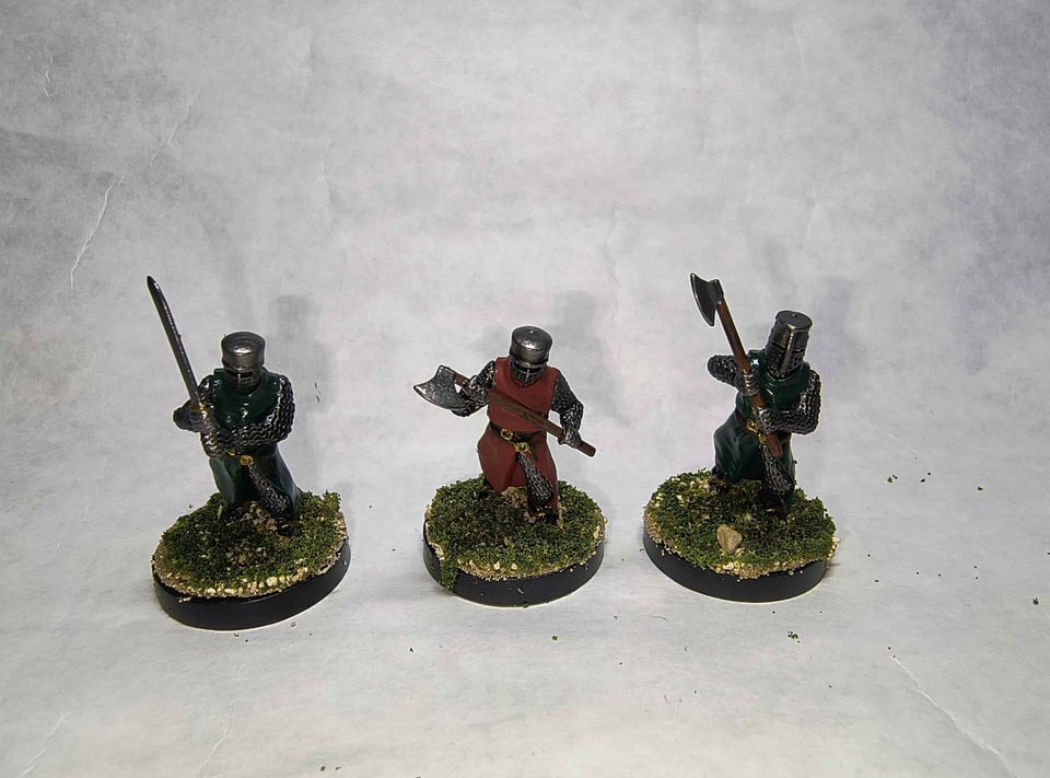 Picture of three knight minis, two with green surcoats, one with a red surcoat.