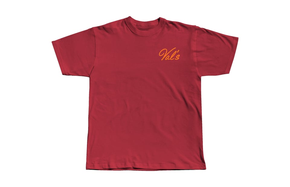 A red t shirt with the word "Val's" printed in orange script in the top right breast pocket area.