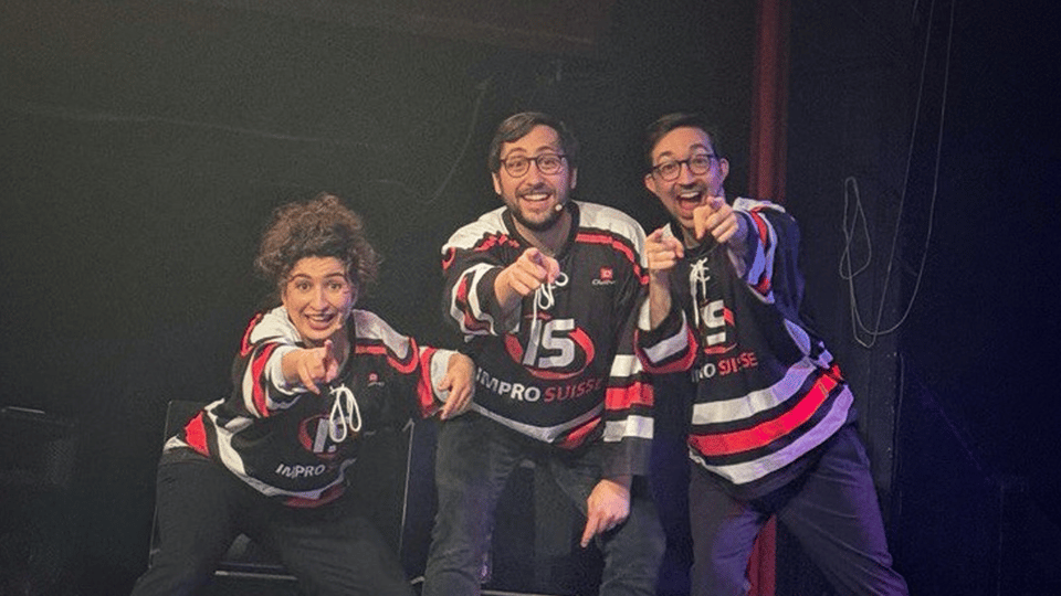 Three people (Amel, Gael and Cédric) in theatre-hockey jerseys pointing straight at the camera.