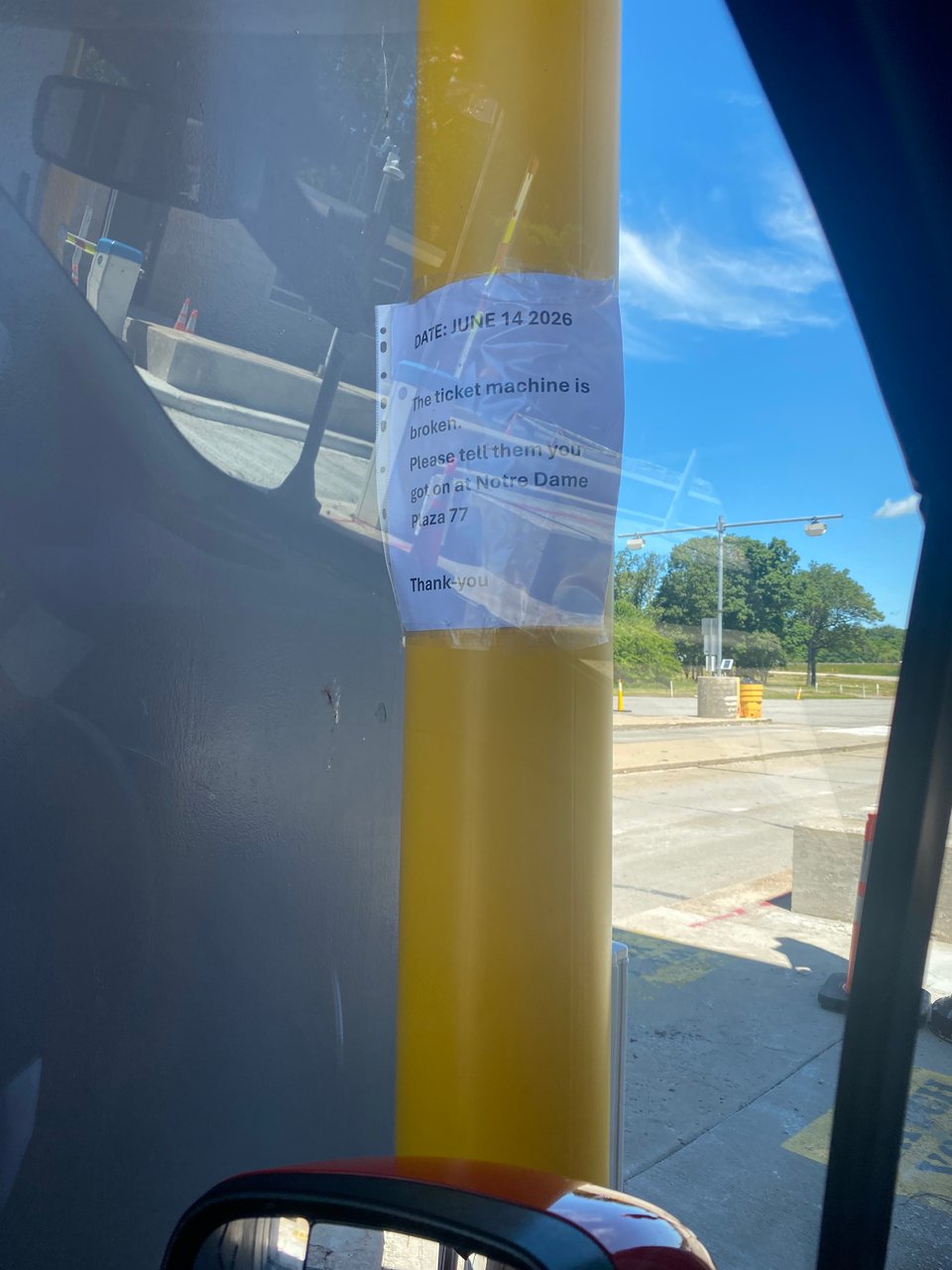 A yellow pole with a sign posted that reads "Date June 14 2026 The ticket machine is broken. Please tell them you got on at Norte Dame Plaza 77 Thank You"