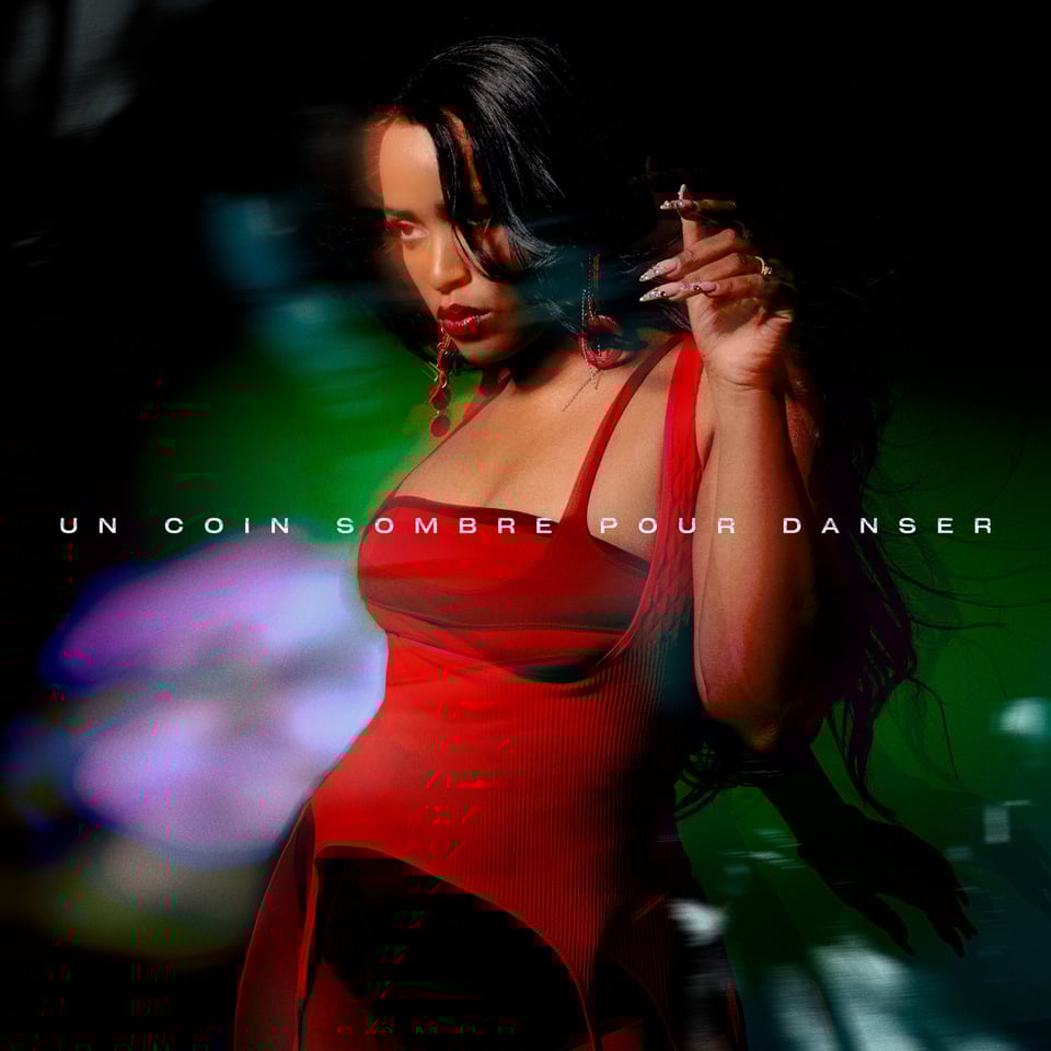 a pretty lady in a bright red outfit vibes in front of a murky background - un coin somebre pour danser