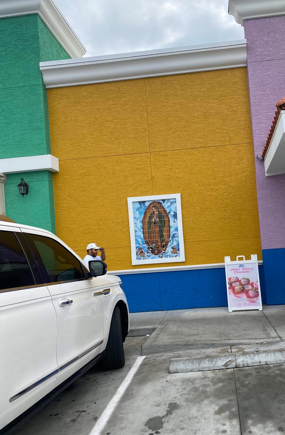 an exterior of a multicolored building with la virgen de guadalupe on the outside
