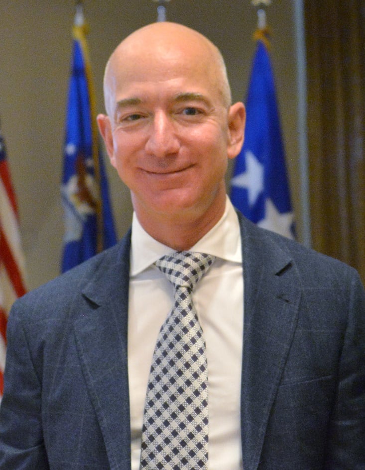 Photo of Jeff Bezos smiling awkwardly at a Space Force event. Image via https://www.dvidshub.net/image/3908618/jeff-bezos-visits-laafb-smc