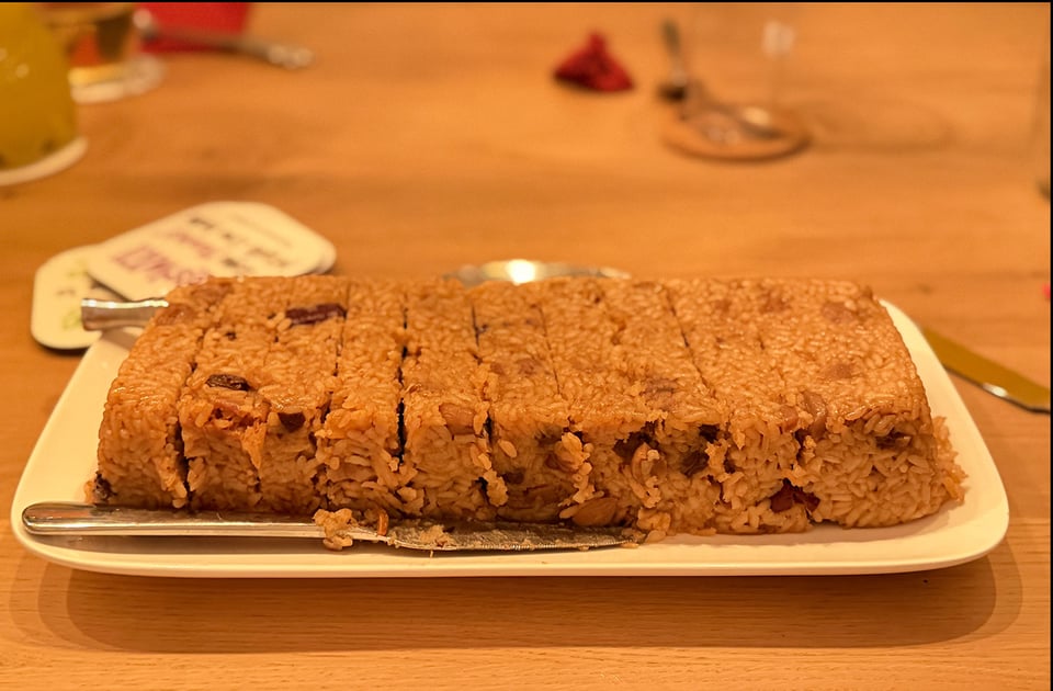 A platter is filled with a rice dessert dish that has been cut into strips.