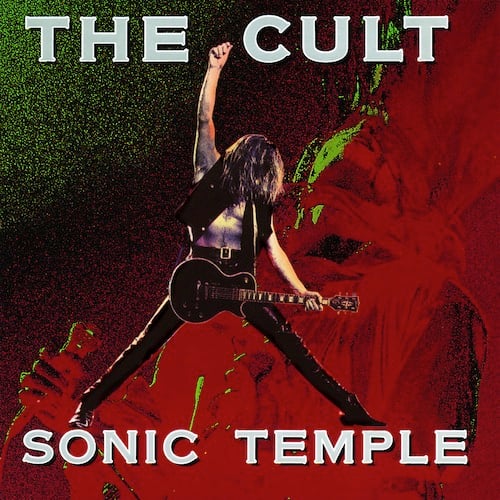 A photo of guitarist Billy Duffy, a white guy with long hair that completely covers his face. He's shirtless save a vest, and wears leather pants. He's taking a triumphant pose, with one hand pointed in the air, the other hand on the neck of the guitar, and his legs spread out -- he forms a kind of triangle shape. This is in front of a heavily distorted close up of singer Ian Astbury, his head thrown back and a microphone in his hand. This picture of him is almost totally in red, with some green highlights.