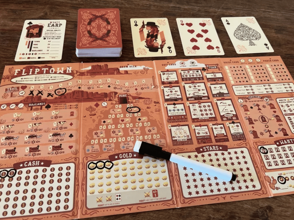 A deck of cards above a sheet of paper with different items marked off. All in a western theme.