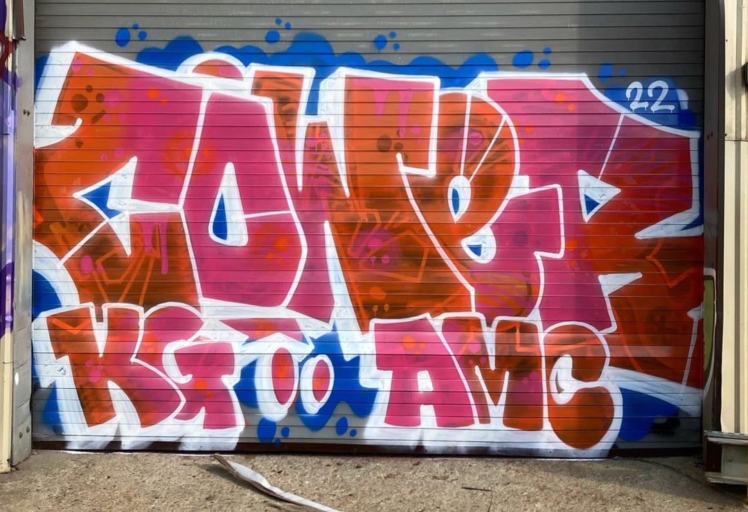 Graffiti on a warehouse door that reads Cower