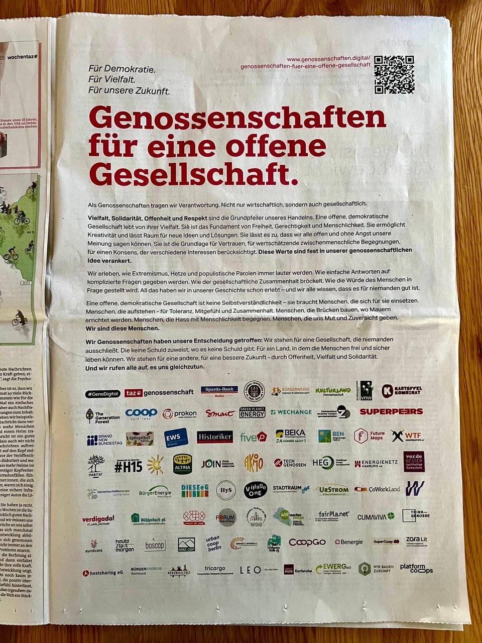 A photo of a full-page ad in a newspaper, under the headline “Genossenschaften für eine offene Gesellschaft”, with 70+ logos of cooperatives who signed the letter