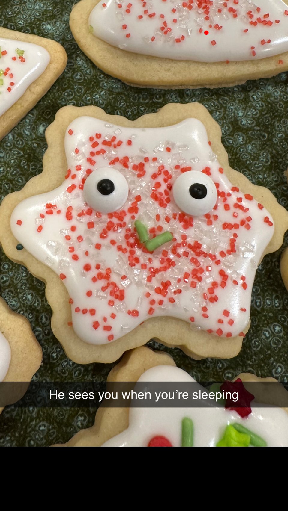 A cursed snowflake with candy eyes and the text “he sees you when you’re sleeping”