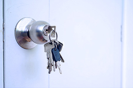 Photo of a with a full ring of keys hanging from the doorknob, so anyone can enter.