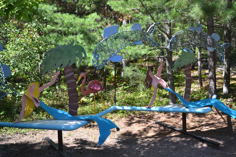 Two metal mermaids on loungers. There's also metal palm trees and a metal flamingo.