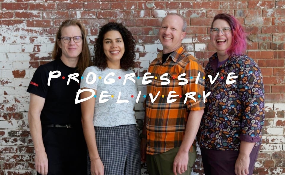 four people standing in front of a brick wall with the words progressive delivery