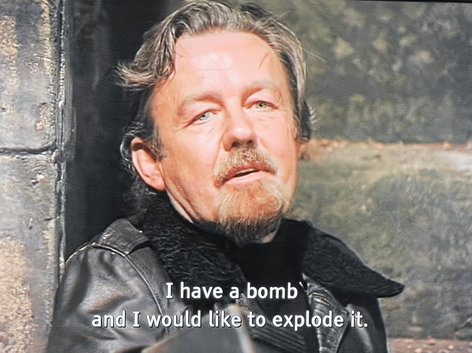 An image from Doctor Who. A grizzled man in leather says "I have a bomb and I would like to explode it"