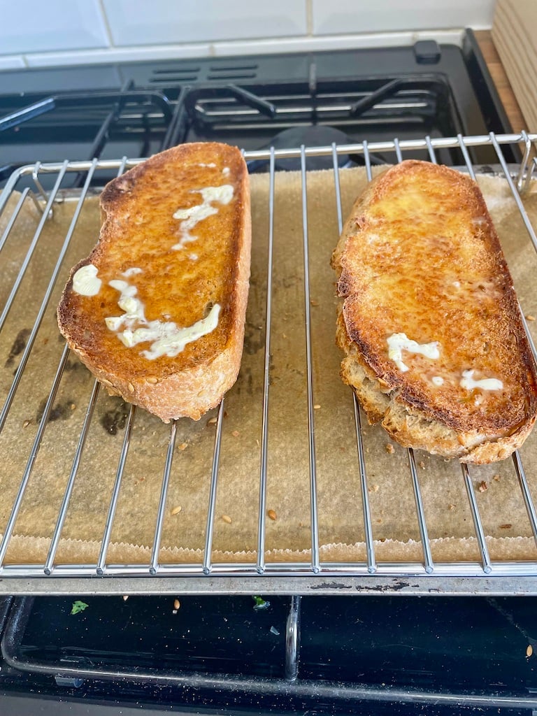 Two slices of buttered toast on a grill