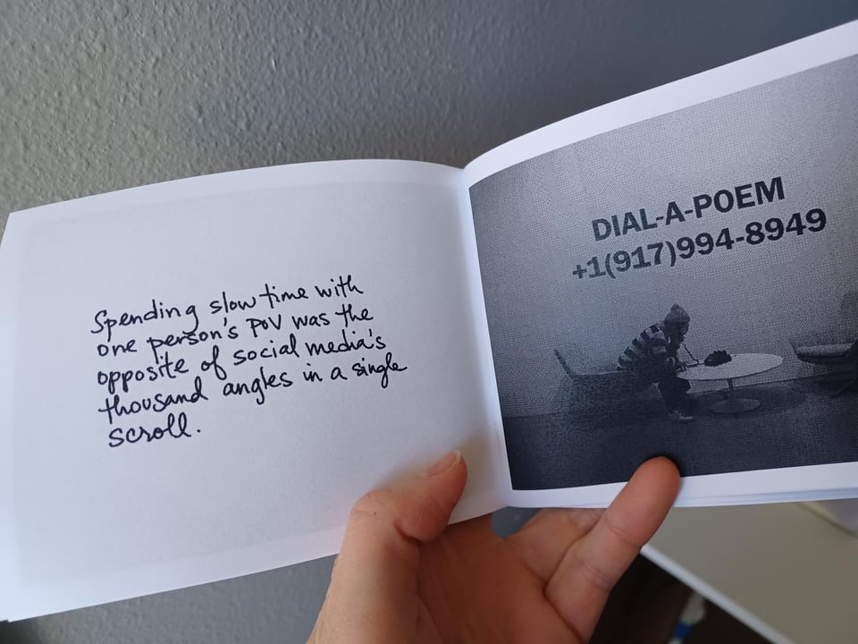 hand holding greyscale zine open to a spread. on the left is a photo with "DIAL-A-POEM +1(917)994-9849" on the wall.