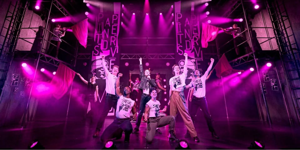 The cast of Pride on a very pink stage.