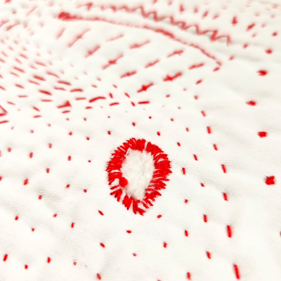 Detail of Red Map showing the original hole surrounded by red thread.