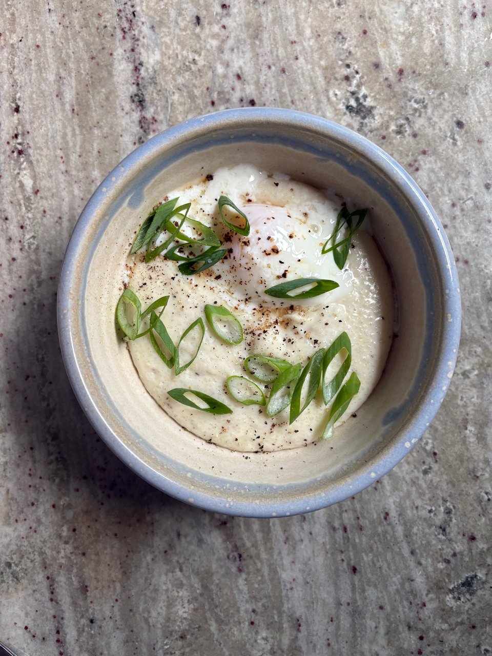 Today's breakfast - quick grits topped with an onsen egg and loaded with cheese, salt, pepper, and green onions