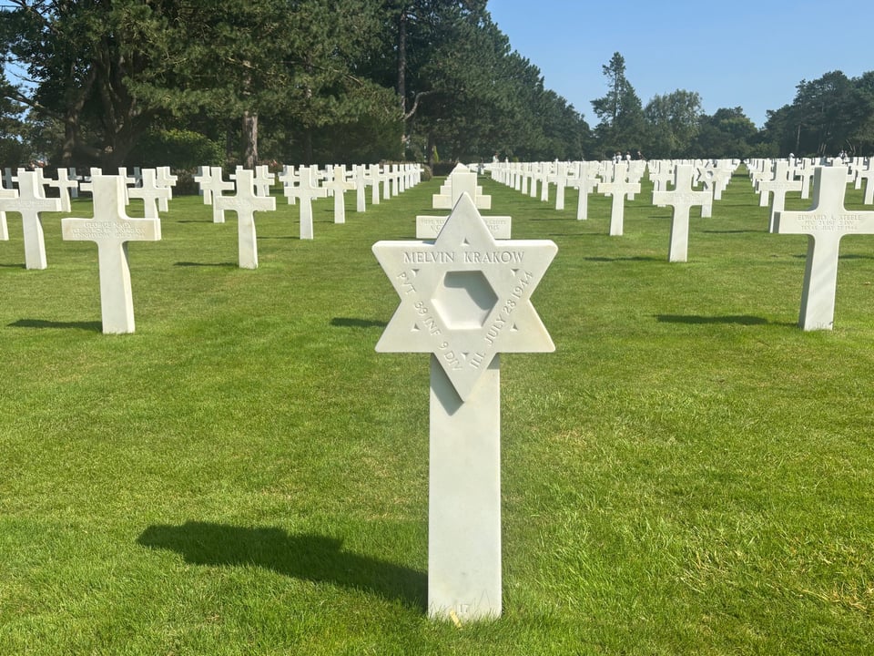 a marker for private melvin krakow, dated july 28, 1944, one of 250-300 jewish markers at the american cemetery in normandy, commemorating all who fell in operation neptune in france