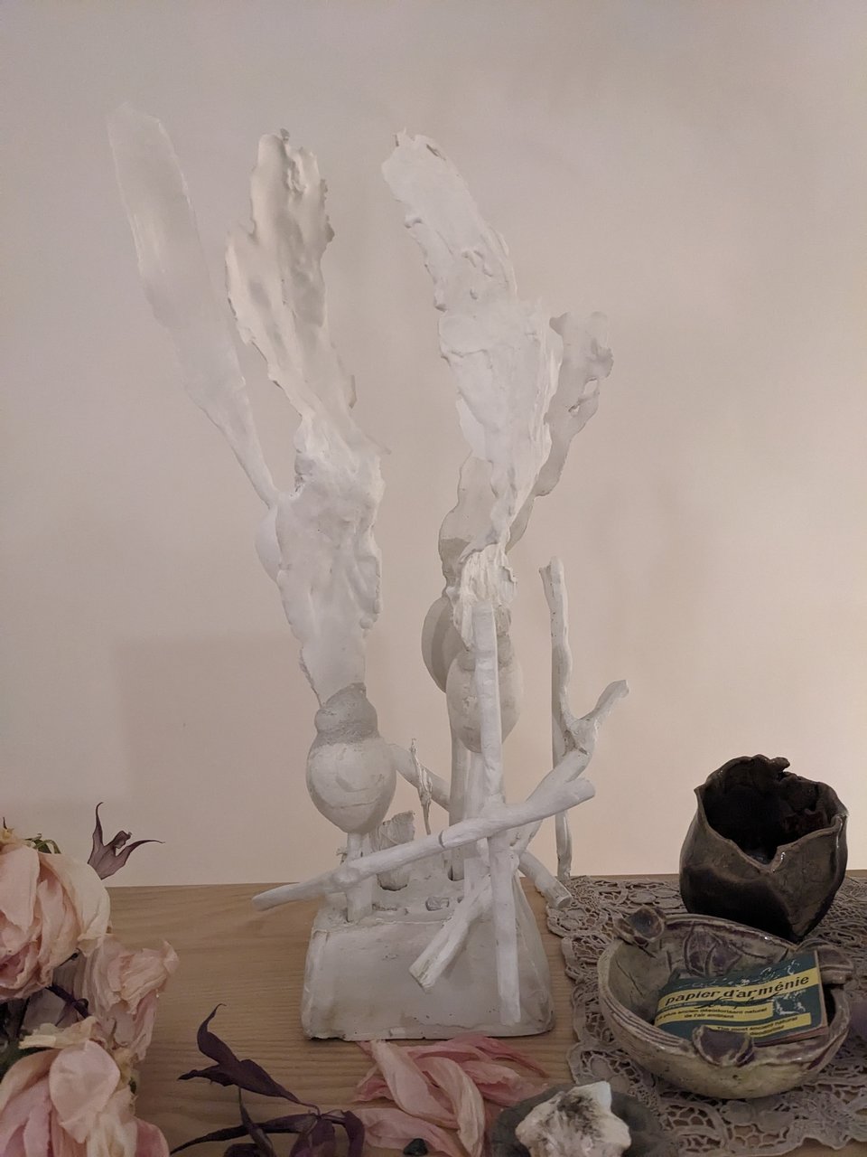 A plaster sculpture with a base, stick-like structures, and kelp bladder and blades
