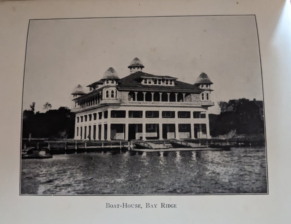 The club's boathouse along the water, a four story building with turrets on each side.